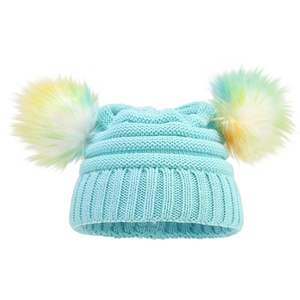 Detail of light blue knit hat with double colorful faux fur pom-poms and ribbed texture