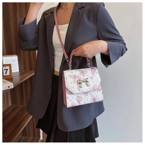 Detail of pink and white butterfly print bag with silver bow clasp and leather straps