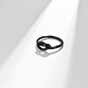Minimalist black stainless steel knot ring for men and women on white background