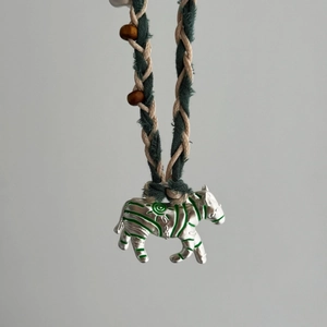 Détail du collier en corde tressée avec pendentif zèbre, perles bois et émail vert
