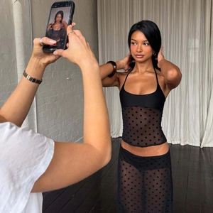 Coulisses du shooting : mannequin portant un ensemble sexy en maille à pois noirs