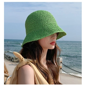 Detail of hand-woven green straw bucket hat with intricate crochet texture for beach