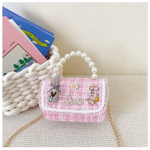 Detail of pink tweed girl bag with pearl handle, 3D floral charms and gold chain strap