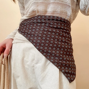 Detail view of a vintage brown floral silk scarf worn as a stylish waist accessory