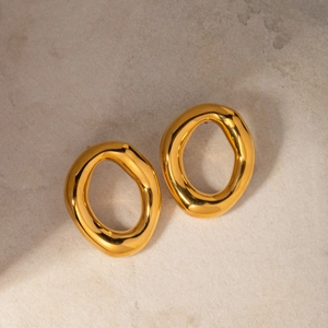 Detailed close-up of 18k gold-plated irregular oval hollow earrings on a stone surface