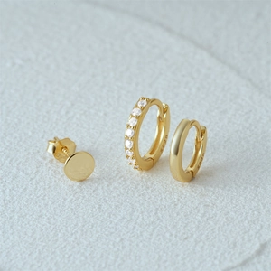 Macro shot of 925 sterling silver gold-plated earring set with clear zircon and S925 hallmark