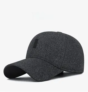 Detail of winter men's wool blend cap with textured dark grey fabric and ear protection