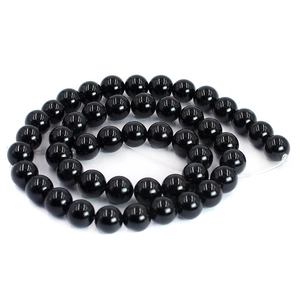 Macro detail of polished natural black agate round beads for DIY jewelry making