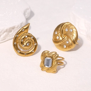 Three-piece set of 18k gold-plated titanium steel rings with rhinestones on stone background