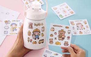 Detail of applying cute bear and duck PVC stickers on a white thermal water bottle