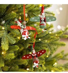 Detail of metal Christmas airplane ornaments with Santa and Reindeer on a lit Xmas tree
