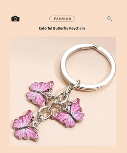 Detail of pink enamel butterfly charms on a polished silver metal keychain ring