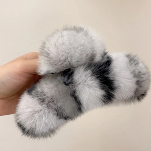 Detailed close-up of large plush faux fur shark hair claw clip in grey and black pattern