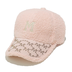 Detailed texture of pink faux shearling baseball cap with M letter embroidery and rhinestones