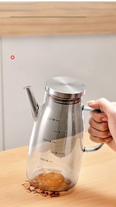 Detail of ergonomic handle and stainless steel lid on a 800ml glass oil dispenser bottle