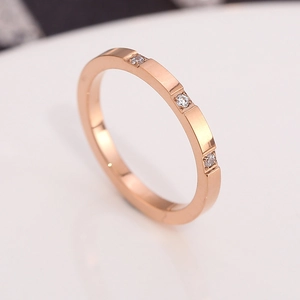 Minimalist rose gold titanium ring with three inlaid diamonds and polished finish