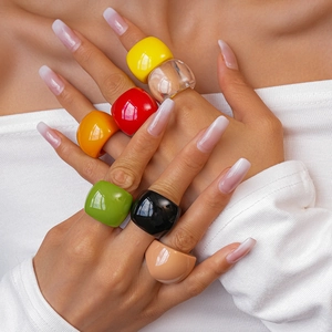 Close-up of vibrant square resin rings in multiple colors on model hands