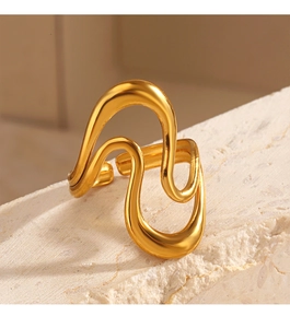 Close-up of a wavy 18K gold-plated stainless steel ring on a textured white stone surface
