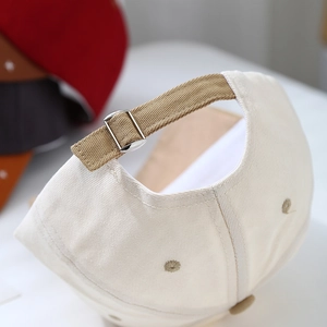 Detail of adjustable metal buckle and dark brown strap on children's baseball cap