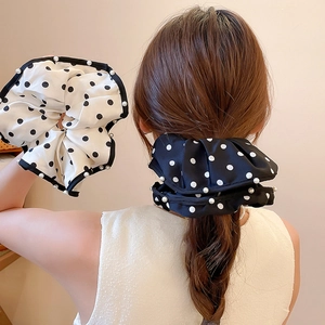 Detailed view of the soft polka dot scrunchie fabric with elegant pearl edge accents