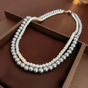 Detail view of double-layer necklace with white pearls and silver metal beads in a jewelry box