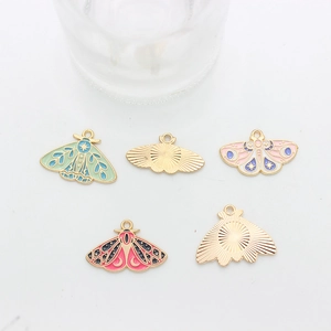 Detailed macro view of colorful enamel moth pendants with intricate moon and star textures