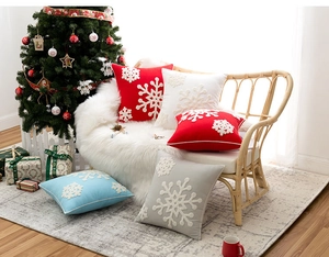 Close-up of festive snowflake embroidery on soft red, white and blue cushion covers