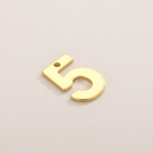 Vue macro d'un pendentif numéro 5 en acier inoxydable doré pour création de bijoux
