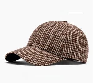 Detailed view of the houndstooth fabric texture and stitching on the wine red baseball cap
