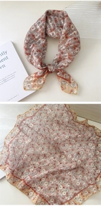 Close-up of knotted cotton linen square scarf with floral daisy pattern and golden edge