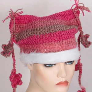 Detailed knit texture of striped cat ear hat with white faux fur trim and braided poms