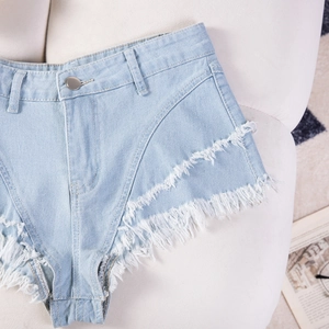 Dettaglio di pantaloncini di jeans celeste con bordi sfrangiati e chiusura con bottone