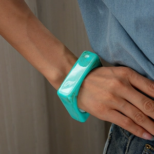 Macro detail of geometric square turquoise acrylic resin bangle with marble texture pattern