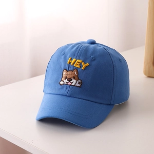 Dettaglio del ricamo HEY e del cucciolo sul cappellino da baseball blu per bambini