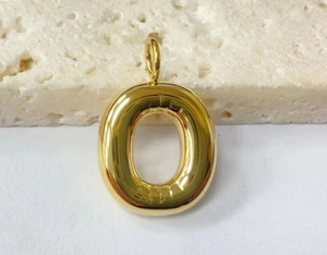 Detailed view of a golden bubble letter O pendant crafted from polished stainless steel