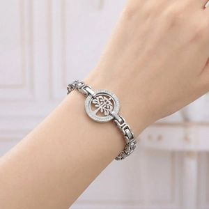 Detail of silver tree of life bracelet with white zircons worn on a female wrist