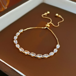 Detail of adjustable gold snake chain bracelet with marquise-cut zircon stones