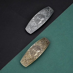 Close-up of vintage Tree of Life alloy hair clips in antique silver and bronze finishes