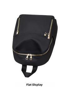 Flat lay view of black nylon backpack with decorative gold zippers and webbing handles
