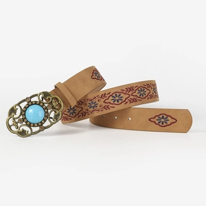 Close-up of vintage metal buckle with turquoise stone and floral ethnic embroidery on belt