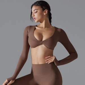 Dettaglio completo del set yoga marrone scuro con top corto a maniche lunghe e nodo frontale