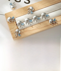 Detail view of jellyfish stud earring with blue zircon teardrop and titanium steel specs