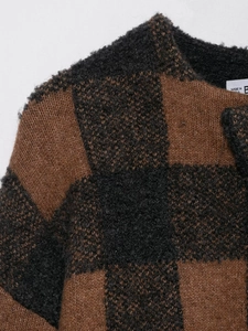 Macro detail of plush checkered knit fabric showing soft mohair texture and neat neckline
