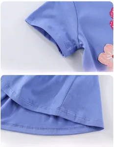 Détail de la broderie fleur rose sur manche bleue et couture à double aiguille
