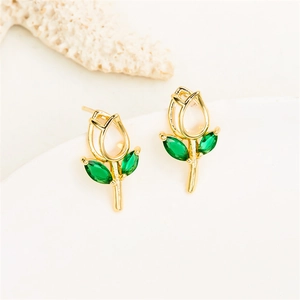 Close-up of golden tulip earrings featuring sparkling green gemstones and petal details