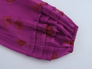 Détail d'une manche en mousseline fleurie violette avec poignets à volants élastiques