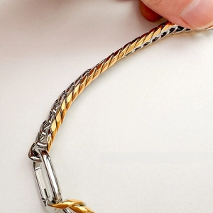 Macro detail of 9mm two-tone gold and silver Miami Cuban link chain with lobster clasp
