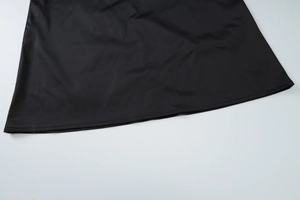 Detail of the smooth hem and precise stitching on the black backless halter maxi dress