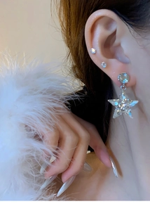Gros plan de boucles d'oreilles étoiles argentées avec cristaux sur un mannequin