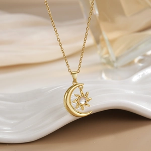 Macro shot of gold-plated sun and moon pendant with shimmering zircon on white tray